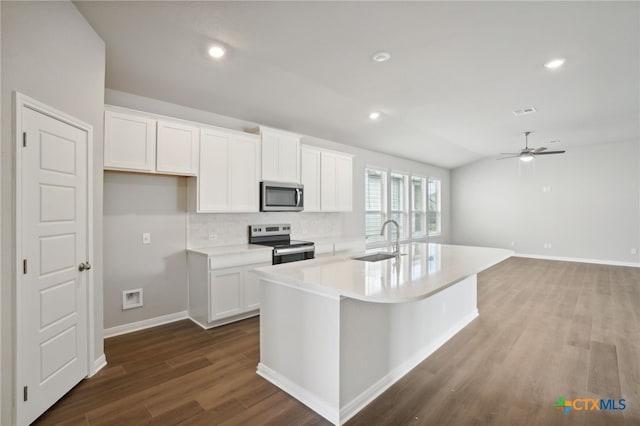 kitchen with sink, stainless steel appliances, a center island with sink, white cabinets, and hardwood / wood-style flooring