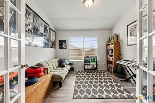 office with vaulted ceiling, wood finished floors, and french doors