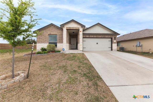 view of front of house featuring an attached garage, brick siding, fence, driveway, and stone siding