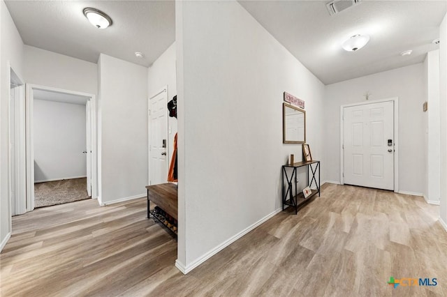 entryway featuring baseboards, visible vents, and light wood finished floors