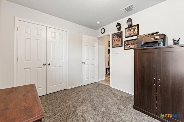 unfurnished bedroom featuring carpet floors, baseboards, visible vents, and a closet