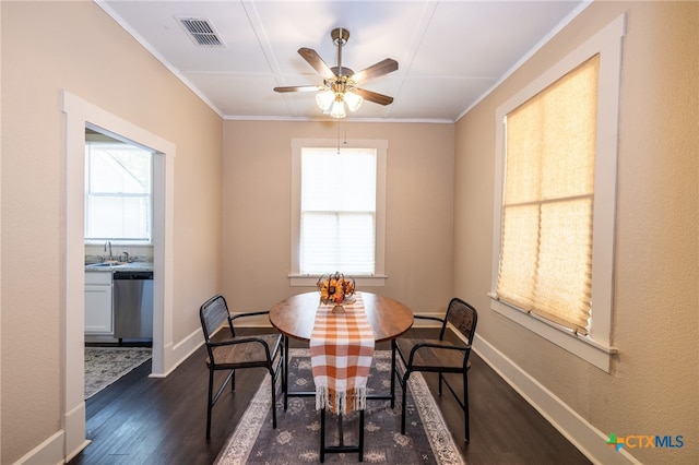 dining area with ceiling fan, sink, ornamental molding, and dark wood-type flooring