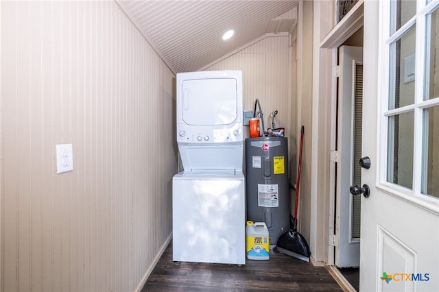 washroom with stacked washing maching and dryer, dark wood-type flooring, wooden walls, and water heater