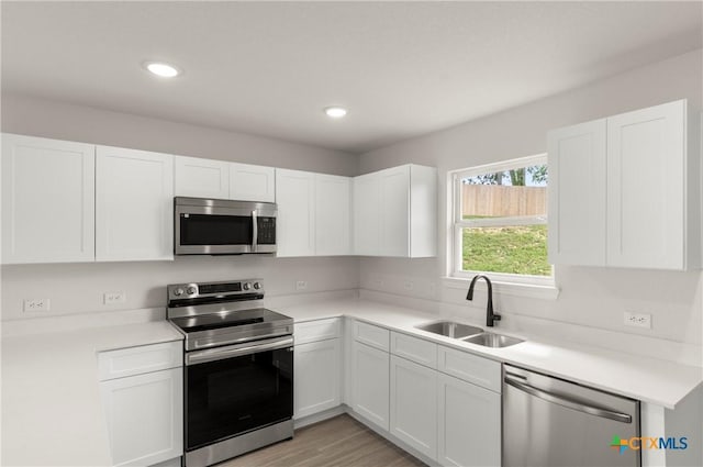 3815 Leming Ct, Temple, TX 76504 - kitchen with appliances with stainless steel finishes, white cabinetry, light countertops, recessed lighting, and light wood-style flooring