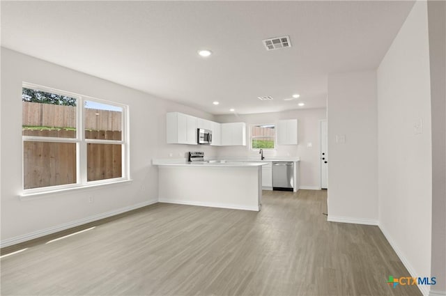 3815 Leming Ct, Temple, TX 76504 - kitchen featuring appliances with stainless steel finishes, light wood-type flooring, light countertops, white cabinetry, and recessed lighting