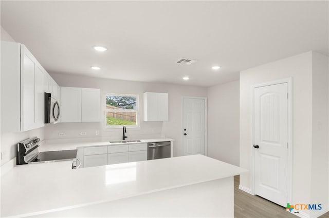 3815 Leming Ct, Temple, TX 76504 - kitchen with appliances with stainless steel finishes, a peninsula, recessed lighting, light countertops, and light wood-style flooring
