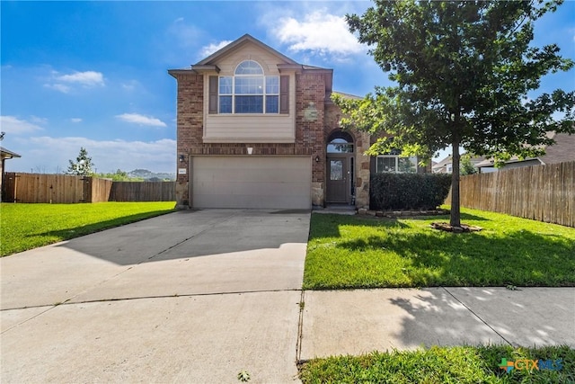 traditional-style home featuring a garage, fence, a front yard, brick siding, and concrete driveway