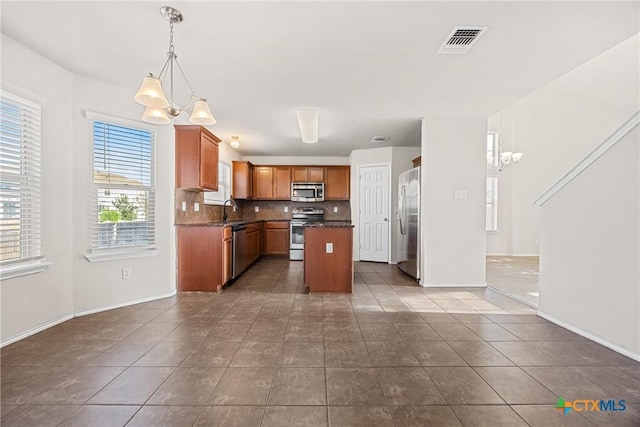 4805 Farrell Ln, Killeen, TX 76549 - kitchen with a chandelier, stainless steel appliances, dark countertops, and backsplash