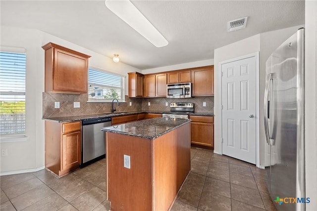 4805 Farrell Ln, Killeen, TX 76549 - kitchen featuring appliances with stainless steel finishes, backsplash, dark tile patterned flooring, and dark stone countertops