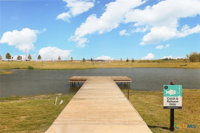 view of dock with a water view, a rural view, and a yard