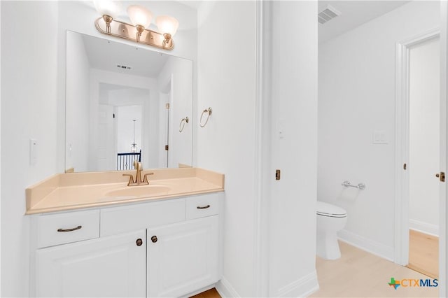 bathroom featuring toilet and vanity