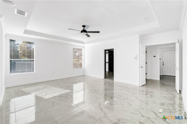 spare room with a raised ceiling and ceiling fan