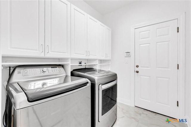 washroom with washer and clothes dryer and cabinets