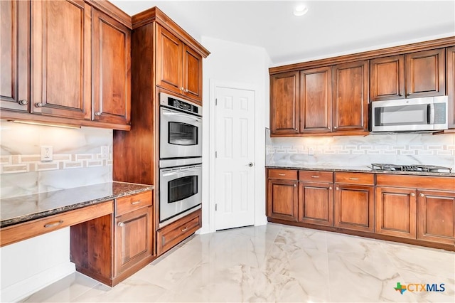 kitchen with backsplash, dark stone counters, and appliances with stainless steel finishes