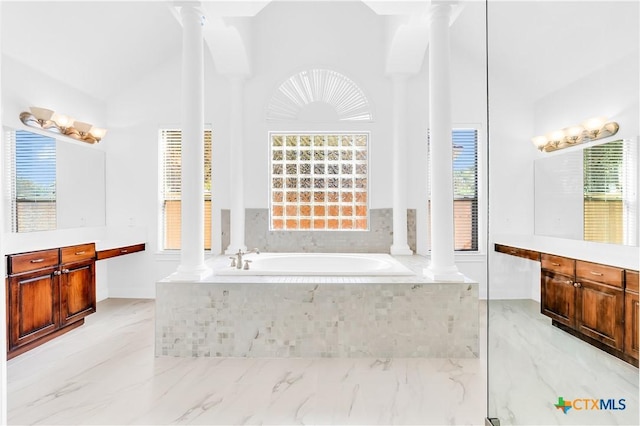 bathroom with vanity, tiled tub, and decorative columns