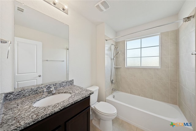 full bathroom featuring tile patterned flooring, vanity, tiled shower / bath combo, and toilet