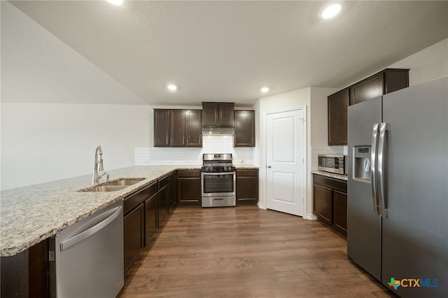 kitchen featuring sink, dark wood-type flooring, backsplash, kitchen peninsula, and appliances with stainless steel finishes