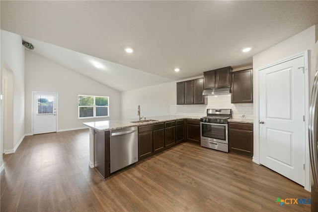 kitchen featuring lofted ceiling, sink, dark hardwood / wood-style floors, kitchen peninsula, and stainless steel appliances