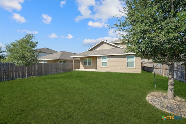 rear view of property featuring a yard and a patio