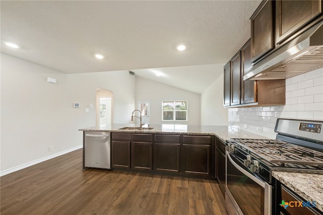 kitchen with extractor fan, appliances with stainless steel finishes, light stone counters, and lofted ceiling