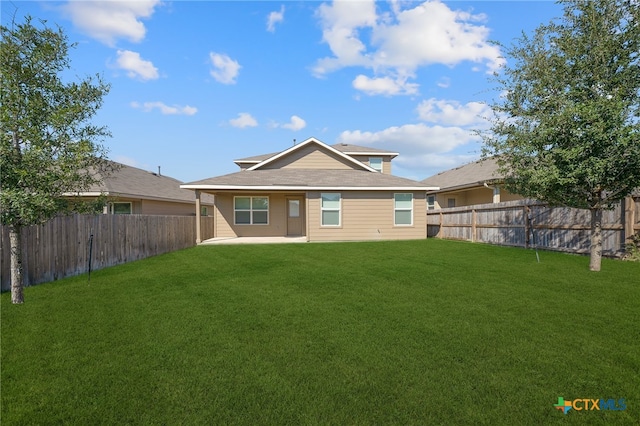 back of property with a lawn and a patio