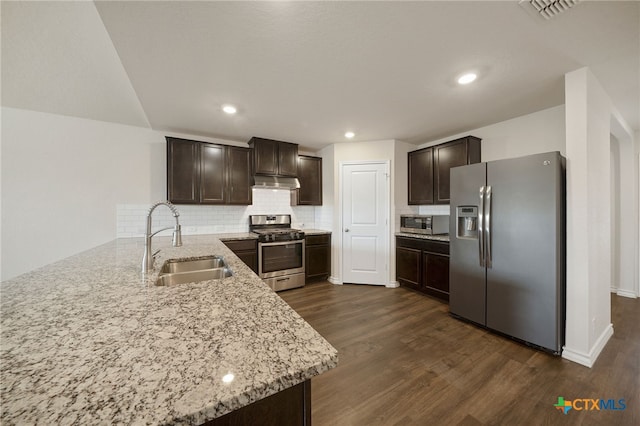 kitchen featuring kitchen peninsula, dark brown cabinetry, sink, and appliances with stainless steel finishes