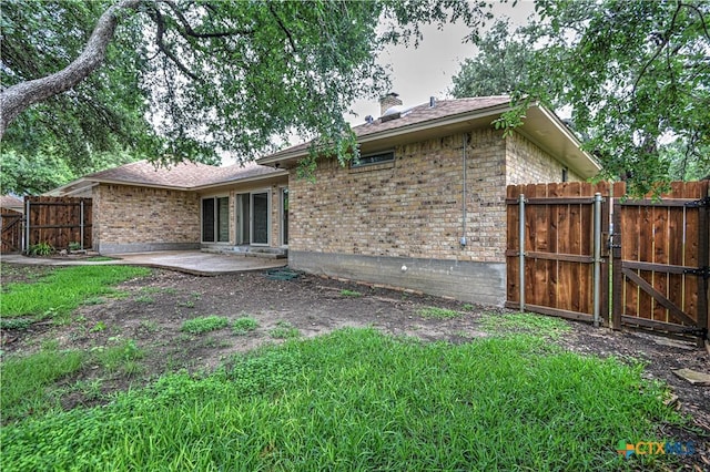 2702 Olympia Dr, Temple, TX 76502 - back of house featuring a gate, brick siding, a chimney, and a patio