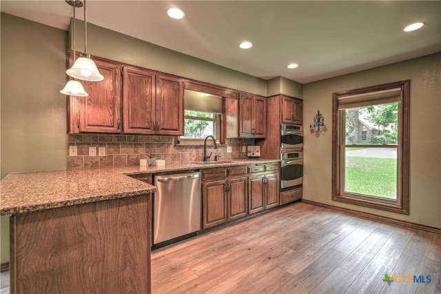 2702 Olympia Dr, Temple, TX 76502 - kitchen with stainless steel dishwasher, tasteful backsplash, light stone countertops, light wood-style flooring, and recessed lighting