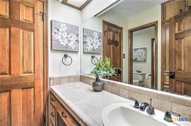 2702 Olympia Dr, Temple, TX 76502 - bathroom featuring vanity, tasteful backsplash, and a textured wall