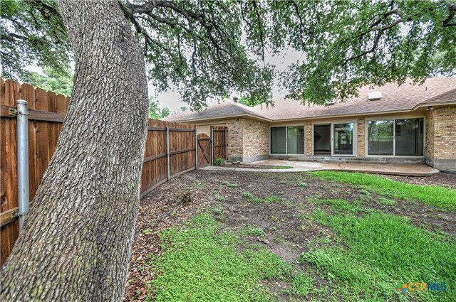 2702 Olympia Dr, Temple, TX 76502 - back of property with brick siding, a fenced backyard, a patio area, and a shingled roof