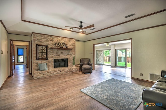 2702 Olympia Dr, Temple, TX 76502 - living room with a ceiling fan, a raised ceiling, hardwood / wood-style floors, a fireplace, and crown molding
