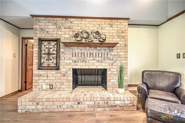 2702 Olympia Dr, Temple, TX 76502 - living area with ornamental molding, wood finished floors, and a brick fireplace