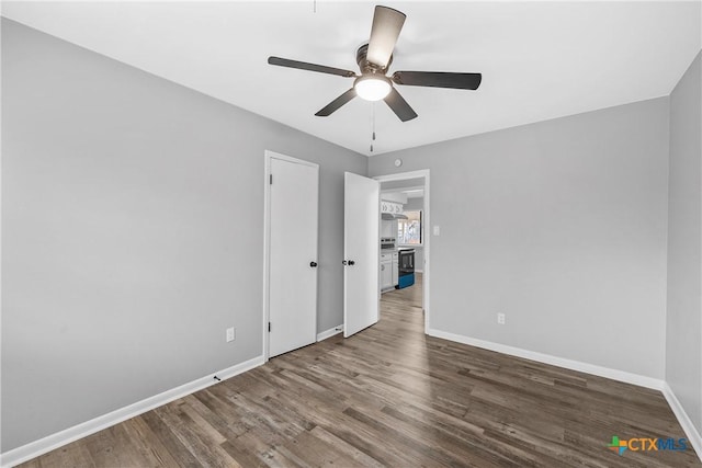 spare room with ceiling fan and dark wood-type flooring