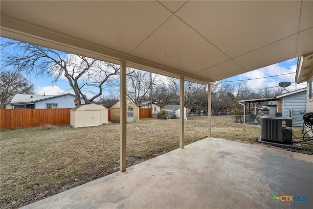 view of patio with a storage shed, a fenced backyard, central AC, and an outdoor structure