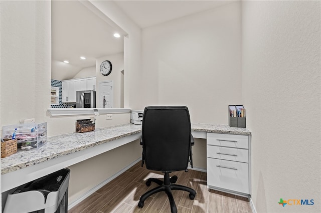 office area with lofted ceiling and built in desk