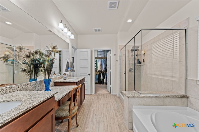 bathroom with vanity, hardwood / wood-style floors, and independent shower and bath