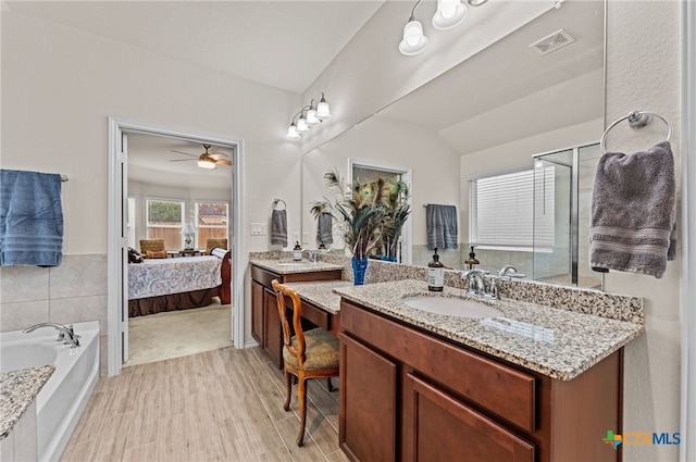 bathroom featuring hardwood / wood-style floors, a tub, lofted ceiling, vanity, and ceiling fan