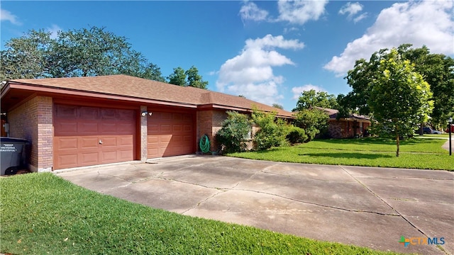 107 Hampton Ct, Victoria, TX 77904 - view of property exterior with driveway, brick siding, a garage, and a yard