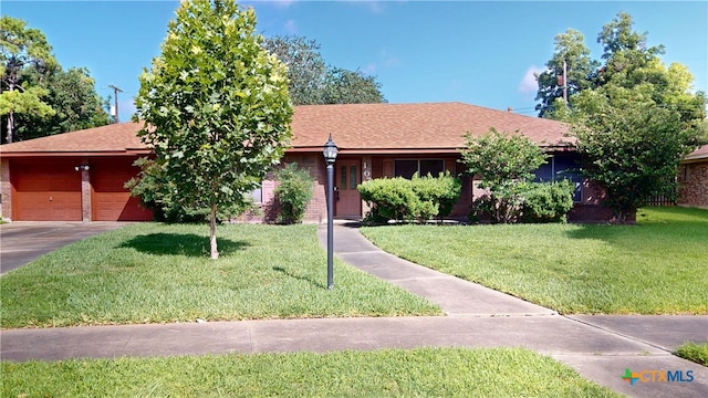 107 Hampton Ct, Victoria, TX 77904 - ranch-style house with a front lawn, brick siding, concrete driveway, and a garage