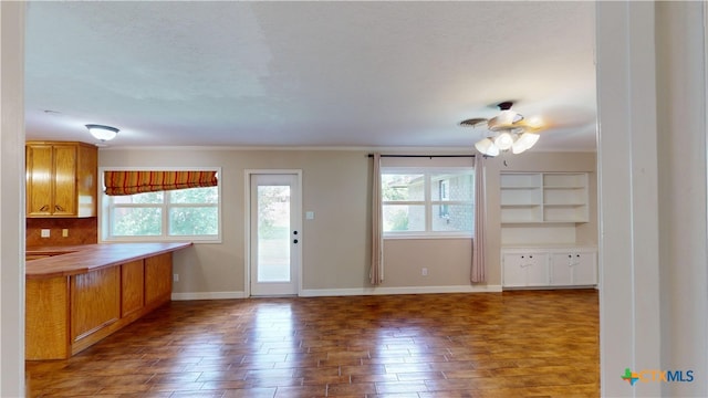 107 Hampton Ct, Victoria, TX 77904 - kitchen with healthy amount of natural light, wood finished floors, crown molding, brown cabinets, and a ceiling fan