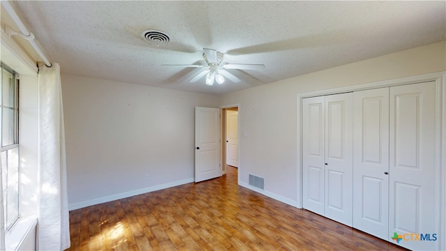 107 Hampton Ct, Victoria, TX 77904 - unfurnished bedroom featuring wood finished floors, a closet, ceiling fan, and a textured ceiling