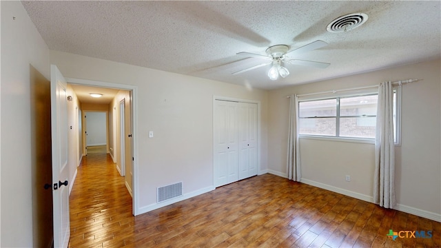 107 Hampton Ct, Victoria, TX 77904 - unfurnished bedroom with light wood-type flooring, a textured ceiling, a closet, and ceiling fan