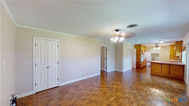 107 Hampton Ct, Victoria, TX 77904 - unfurnished living room with dark wood-type flooring, a ceiling fan, ornamental molding, and a textured ceiling