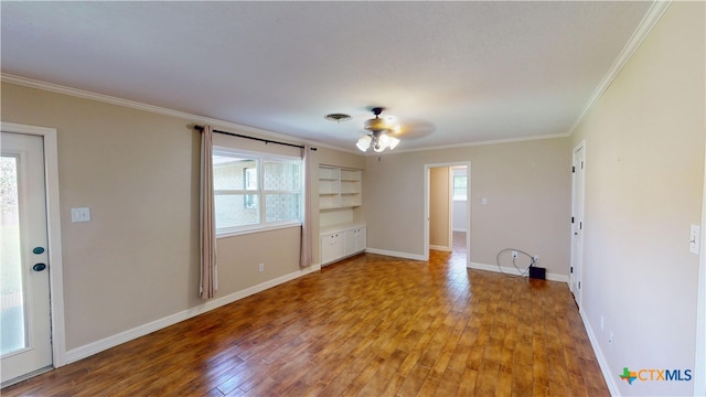 107 Hampton Ct, Victoria, TX 77904 - spare room featuring ornamental molding, healthy amount of natural light, wood finished floors, and built in shelves