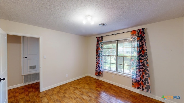 107 Hampton Ct, Victoria, TX 77904 - spare room featuring wood finished floors and a textured ceiling
