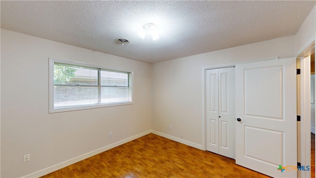 107 Hampton Ct, Victoria, TX 77904 - unfurnished bedroom featuring wood finished floors, a closet, and a textured ceiling