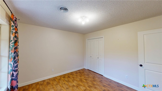 107 Hampton Ct, Victoria, TX 77904 - unfurnished bedroom with wood finished floors, a closet, and a textured ceiling
