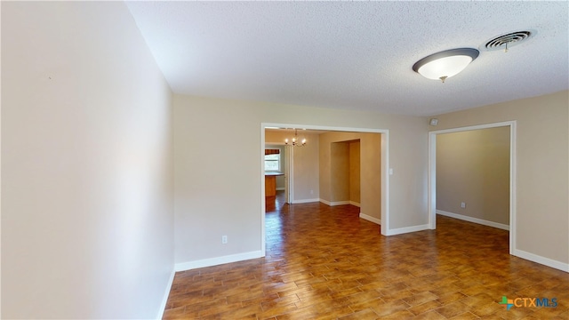 107 Hampton Ct, Victoria, TX 77904 - unfurnished room with a chandelier, wood finished floors, and a textured ceiling