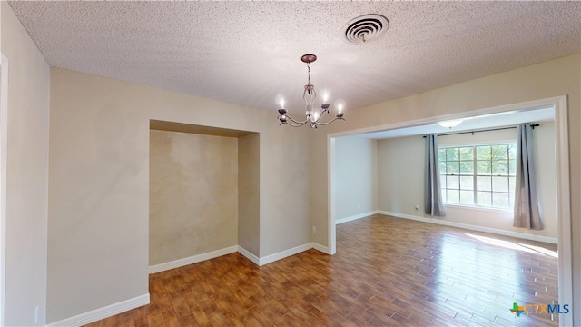 107 Hampton Ct, Victoria, TX 77904 - unfurnished room featuring wood finished floors, a chandelier, and a textured ceiling