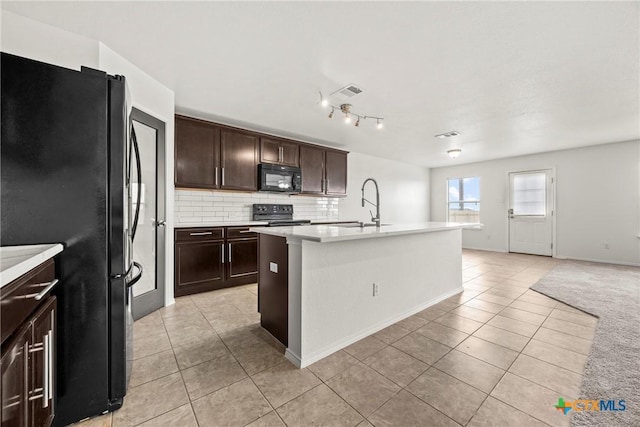 306 W Gemini Ln, Killeen, TX 76542 - kitchen featuring black appliances, light tile patterned flooring, tasteful backsplash, light countertops, and dark brown cabinets